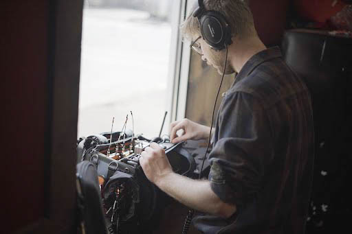 Sound Mixer Joe Vnuck working on location adjusting levels on his sound mixer. 